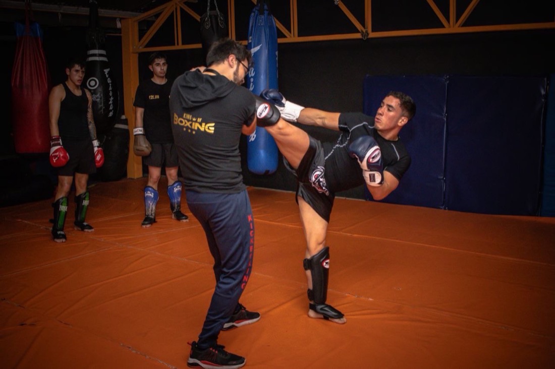 Sesion tecnica sobre manoplas en un gimnasio de boxeo